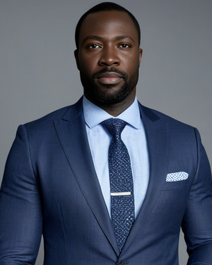 Ein Mann in einem eleganten blauen Anzug mit Krawatte und Hemd, der direkt in die Kamera schaut. Er trägt eine Armbanduhr.