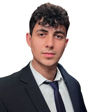 Junger Mann mit lockigem Haar, der einen Anzug und eine Krawatte trägt. Er schaut direkt in die Kamera und hat einen neutralen Gesichtsausdruck. Der Hintergrund ist einfarbig weiß.